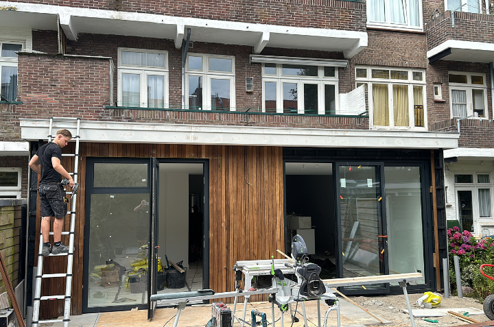 Aanbouw met houten gevelbekleding en glazen puien in Den Haag